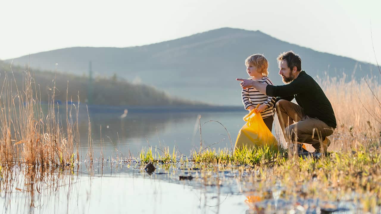 Un père et son fils nettoient un lac